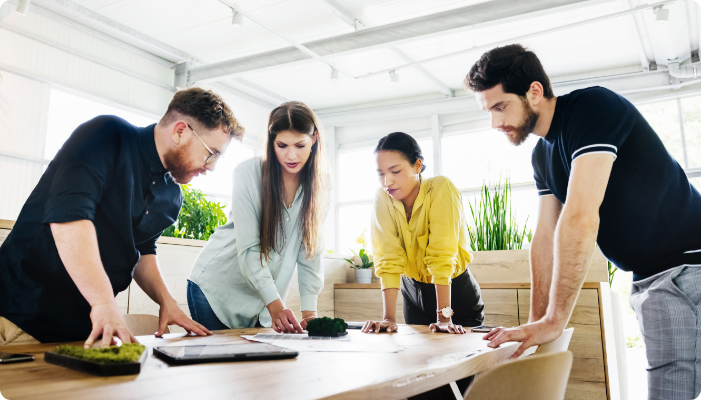 A group of associates talking at a desk.